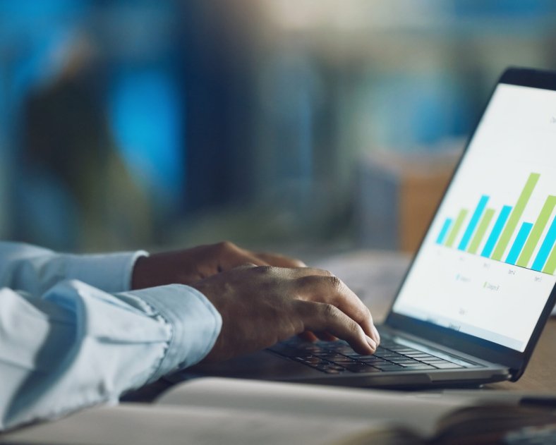 Closeup hands of african man working on a laptop. African american business man using a computer wh.